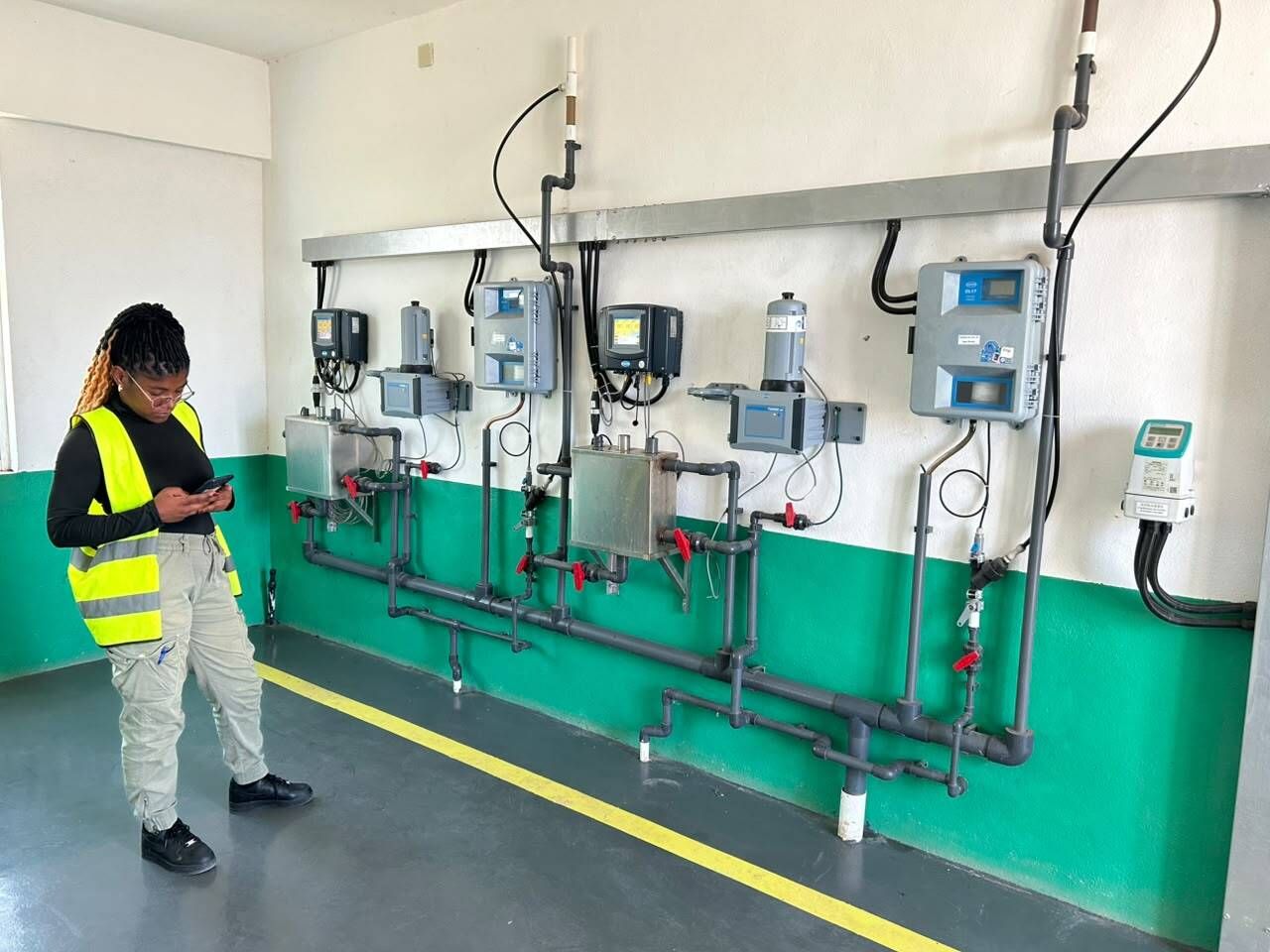 An inspector records readings from water-quality monitoring equipment at a treatment plant in Bié, Angola